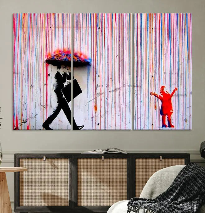 Introducing the Banksy Street Art Wall Art Canvas Print, a captivating piece featuring modern art of a man with an umbrella while a child reaches up through vibrant drips. Its premium canvas and gallery-quality finish make it an eye-catching addition to any space.