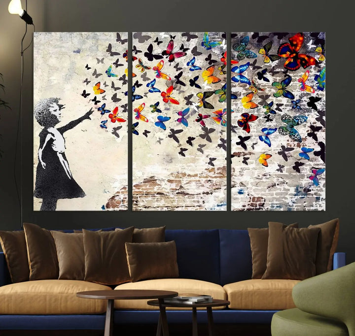 The Banksy Style Wall Art Print, featuring the Banksy Girl with Butterflies design, is a beautiful framed ready-to-hang triptych canvas that depicts a child releasing vibrant butterflies. It creates an enchanting tribute reminiscent of a Banksy scene.