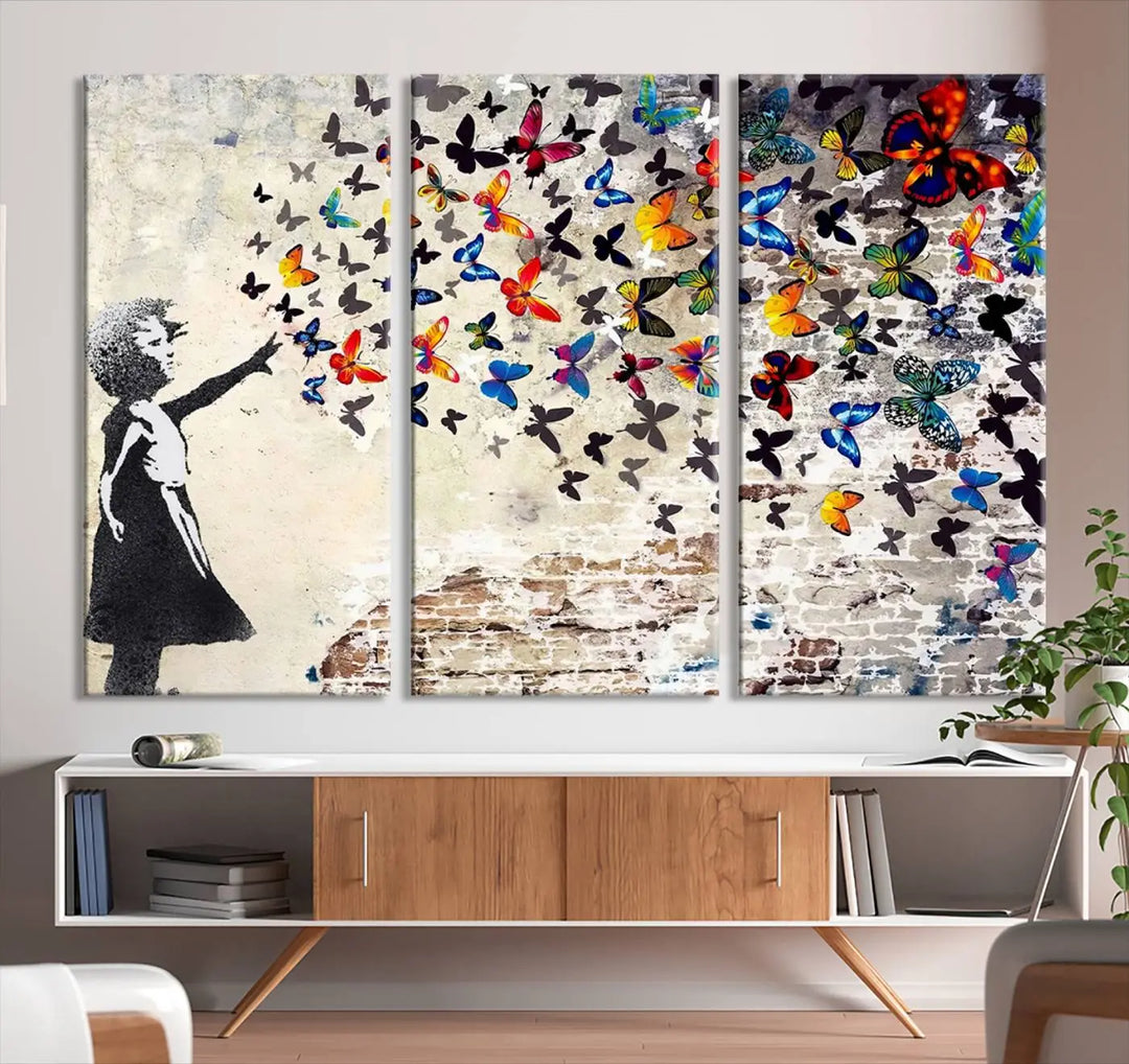 The Banksy Style Wall Art Print, featuring the Banksy Girl with Butterflies design, is a beautiful framed ready-to-hang triptych canvas that depicts a child releasing vibrant butterflies. It creates an enchanting tribute reminiscent of a Banksy scene.