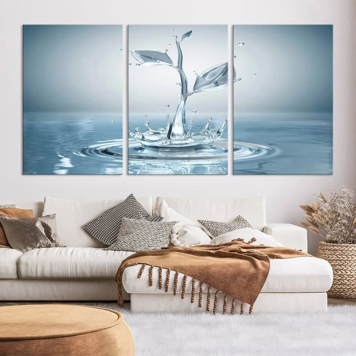 The living room features a three-panel wall art titled "Bathroom Wall Art Blue Leaf Canvas," showcasing water splash shapes that form plant-like designs on gallery-wrapped, museum-quality canvas.