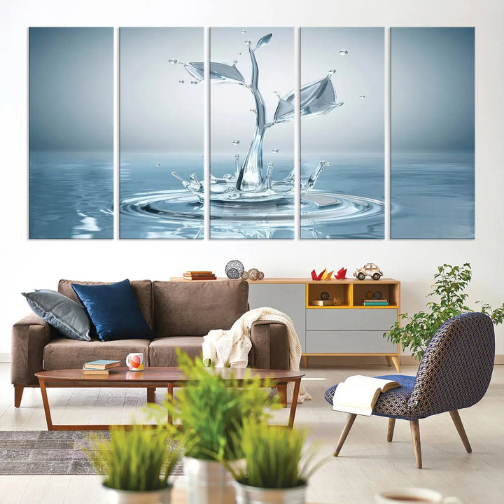 The living room features a three-panel wall art titled "Bathroom Wall Art Blue Leaf Canvas," showcasing water splash shapes that form plant-like designs on gallery-wrapped, museum-quality canvas.