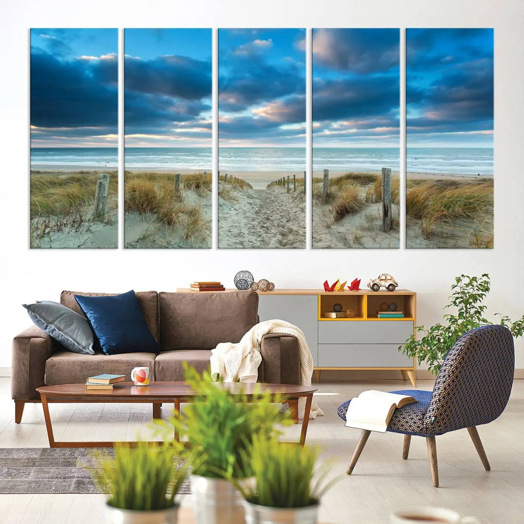 The "Beach Ocean Sun Sand Wall Art Canvas Print" is a triptych showcasing a beach path with grass leading to the ocean under a dramatic cloudy sky. This museum-quality canvas includes a UV-protective coating for longevity and vibrancy, and it comes ready to hang for effortless elegance.