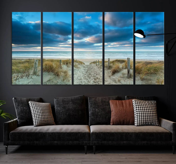 The "Beach Ocean Sun Sand Wall Art Canvas Print" is a triptych showcasing a beach path with grass leading to the ocean under a dramatic cloudy sky. This museum-quality canvas includes a UV-protective coating for longevity and vibrancy, and it comes ready to hang for effortless elegance.