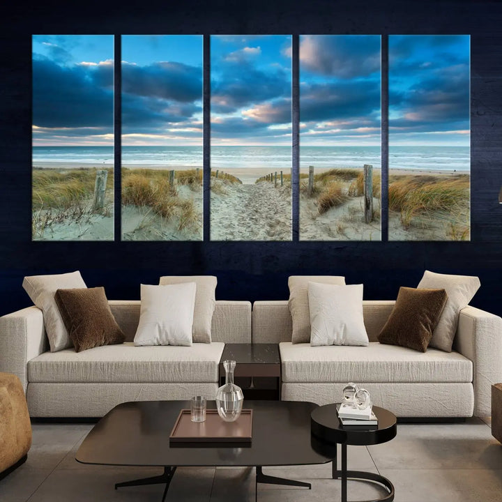 The "Beach Ocean Sun Sand Wall Art Canvas Print" is a triptych showcasing a beach path with grass leading to the ocean under a dramatic cloudy sky. This museum-quality canvas includes a UV-protective coating for longevity and vibrancy, and it comes ready to hang for effortless elegance.