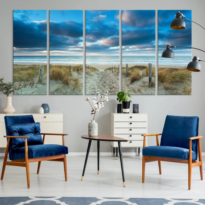 The "Beach Ocean Sun Sand Wall Art Canvas Print" is a triptych showcasing a beach path with grass leading to the ocean under a dramatic cloudy sky. This museum-quality canvas includes a UV-protective coating for longevity and vibrancy, and it comes ready to hang for effortless elegance.