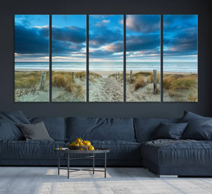 The "Beach Ocean Sun Sand Wall Art Canvas Print" is a triptych showcasing a beach path with grass leading to the ocean under a dramatic cloudy sky. This museum-quality canvas includes a UV-protective coating for longevity and vibrancy, and it comes ready to hang for effortless elegance.