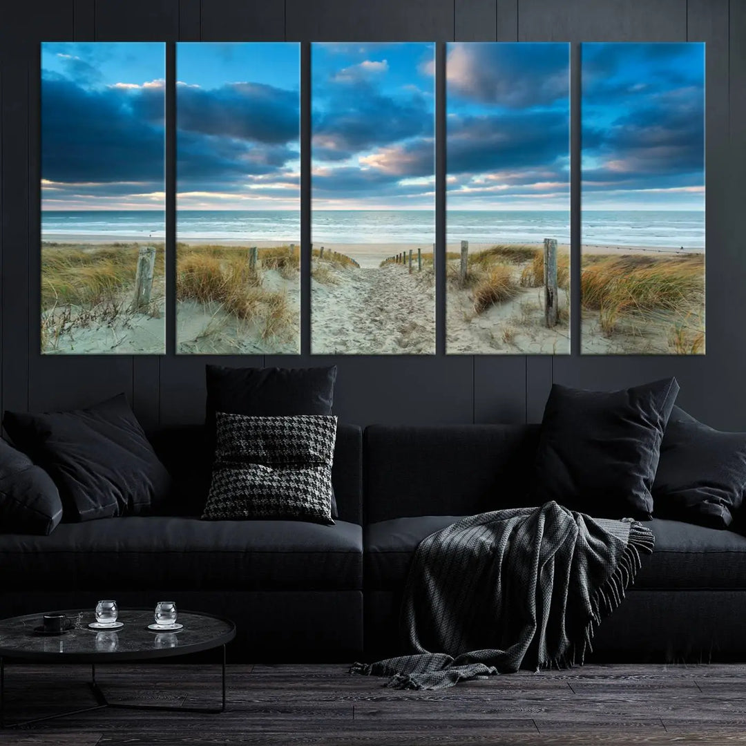 The "Beach Ocean Sun Sand Wall Art Canvas Print" is a triptych showcasing a beach path with grass leading to the ocean under a dramatic cloudy sky. This museum-quality canvas includes a UV-protective coating for longevity and vibrancy, and it comes ready to hang for effortless elegance.