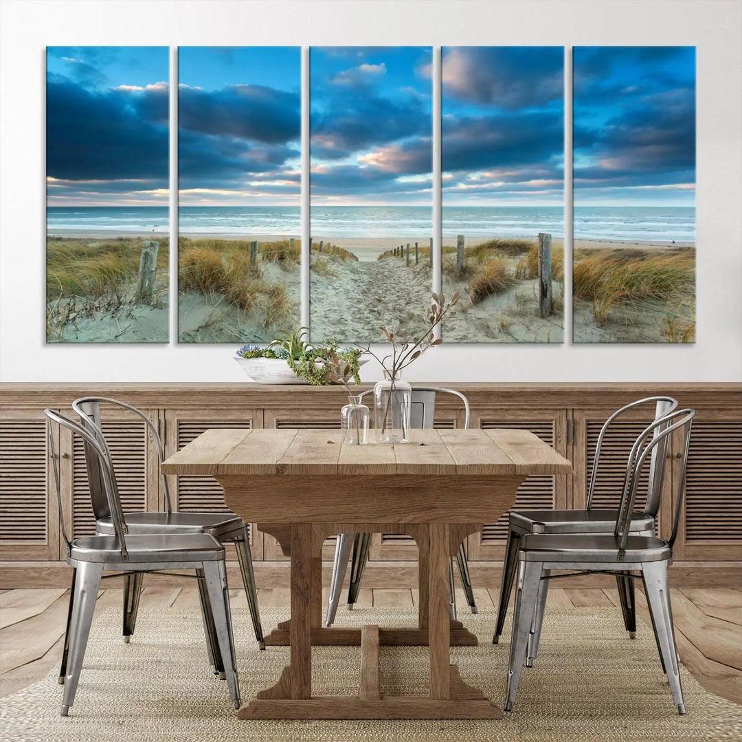 The "Beach Ocean Sun Sand Wall Art Canvas Print" is a triptych showcasing a beach path with grass leading to the ocean under a dramatic cloudy sky. This museum-quality canvas includes a UV-protective coating for longevity and vibrancy, and it comes ready to hang for effortless elegance.