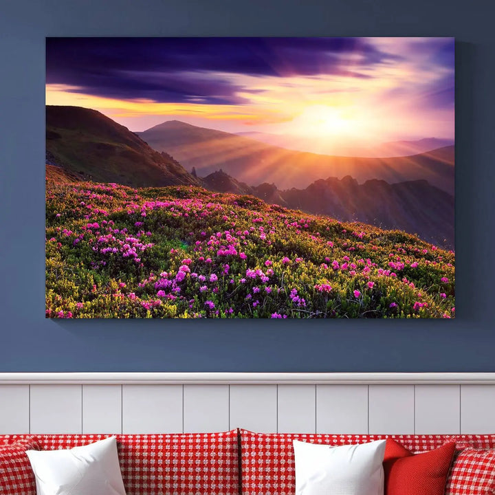 A living room showcases the Beautiful Mountain Sunset Landscape with Purple Flowers Canvas Wall Art Print, featuring a triptych of a vibrant sunset over mountains and blooming flowers, vividly rendered on museum-quality canvas with UV-protective coating.