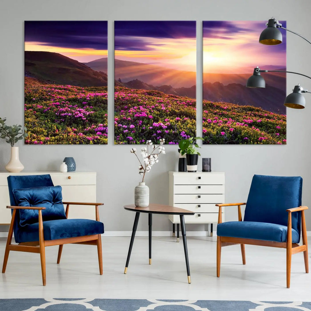 A living room showcases the Beautiful Mountain Sunset Landscape with Purple Flowers Canvas Wall Art Print, featuring a triptych of a vibrant sunset over mountains and blooming flowers, vividly rendered on museum-quality canvas with UV-protective coating.