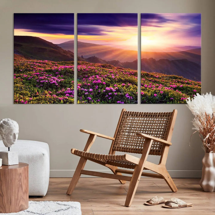 A living room showcases the Beautiful Mountain Sunset Landscape with Purple Flowers Canvas Wall Art Print, featuring a triptych of a vibrant sunset over mountains and blooming flowers, vividly rendered on museum-quality canvas with UV-protective coating.