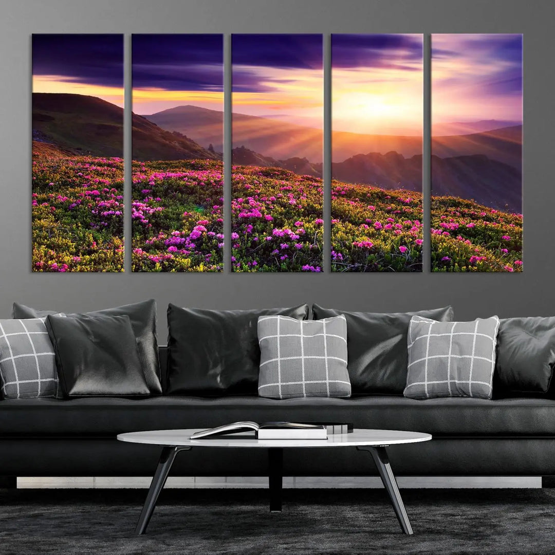 A living room showcases the Beautiful Mountain Sunset Landscape with Purple Flowers Canvas Wall Art Print, featuring a triptych of a vibrant sunset over mountains and blooming flowers, vividly rendered on museum-quality canvas with UV-protective coating.