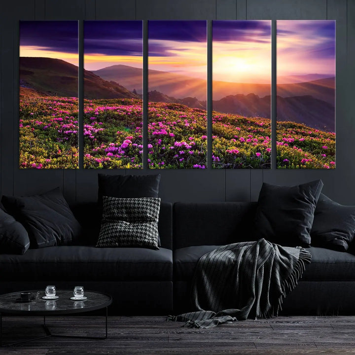 A living room showcases the Beautiful Mountain Sunset Landscape with Purple Flowers Canvas Wall Art Print, featuring a triptych of a vibrant sunset over mountains and blooming flowers, vividly rendered on museum-quality canvas with UV-protective coating.