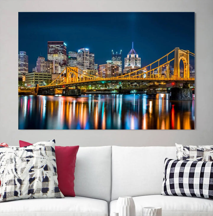 A cityscape at night showcases the illuminated beauty of Pittsburgh, with its bridge and skyscrapers casting glowing reflections on the river, all beautifully captured on this museum-quality canvas titled "Beautiful Pittsburgh Skyline Wall Art.