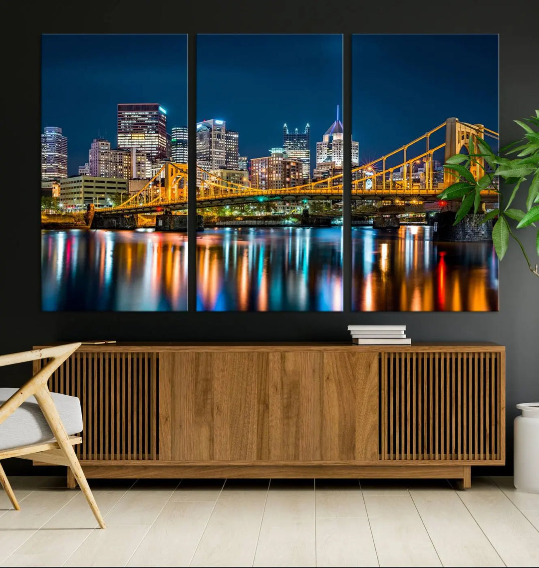 A cityscape at night showcases the illuminated beauty of Pittsburgh, with its bridge and skyscrapers casting glowing reflections on the river, all beautifully captured on this museum-quality canvas titled "Beautiful Pittsburgh Skyline Wall Art.