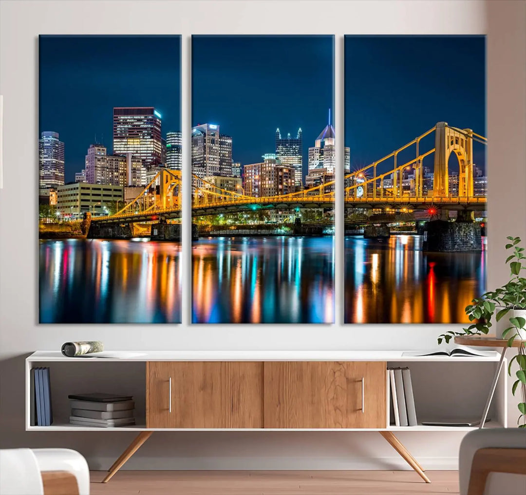 A cityscape at night showcases the illuminated beauty of Pittsburgh, with its bridge and skyscrapers casting glowing reflections on the river, all beautifully captured on this museum-quality canvas titled "Beautiful Pittsburgh Skyline Wall Art.