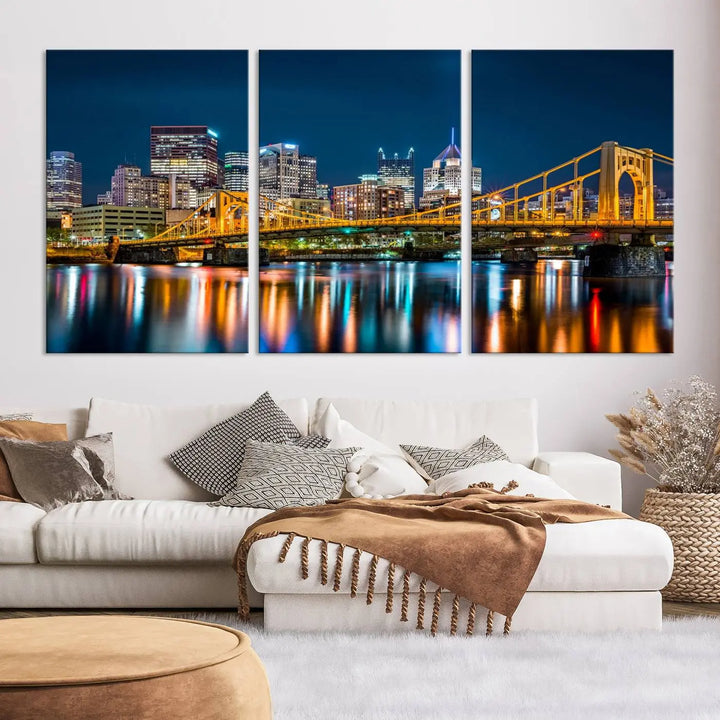 A cityscape at night showcases the illuminated beauty of Pittsburgh, with its bridge and skyscrapers casting glowing reflections on the river, all beautifully captured on this museum-quality canvas titled "Beautiful Pittsburgh Skyline Wall Art.