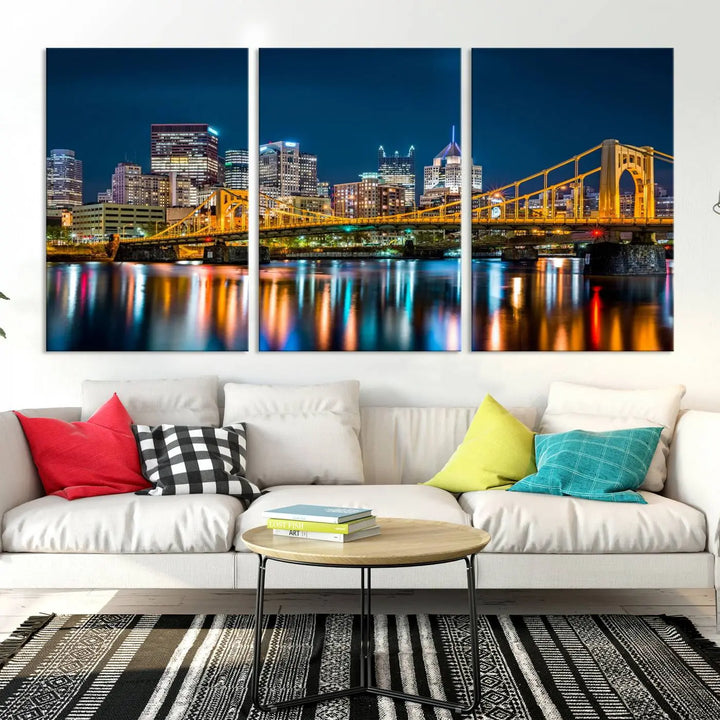 A cityscape at night showcases the illuminated beauty of Pittsburgh, with its bridge and skyscrapers casting glowing reflections on the river, all beautifully captured on this museum-quality canvas titled "Beautiful Pittsburgh Skyline Wall Art.