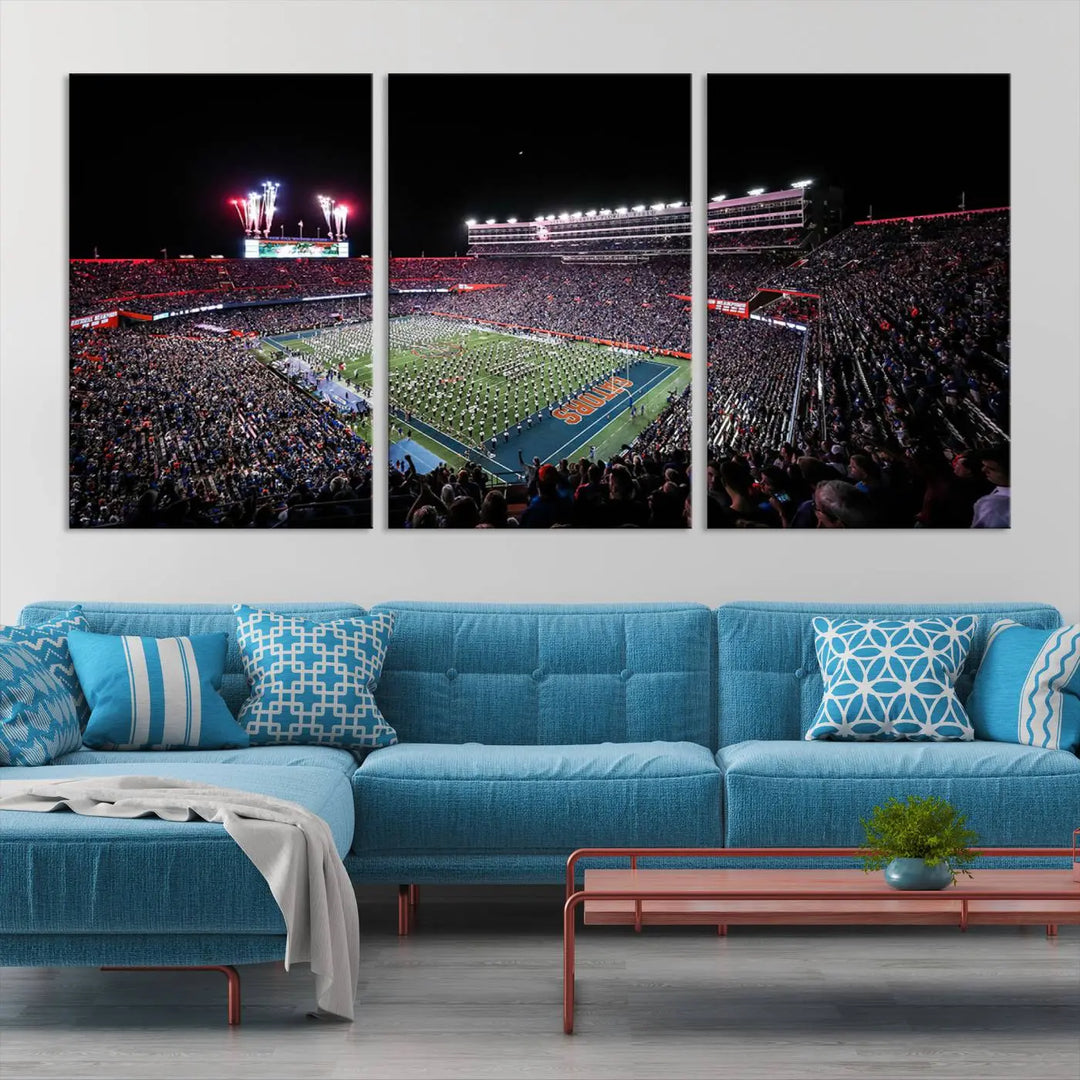 The Ben Hill Griffin Stadium Night Game Triple Canvas Wall Art - Florida Gators Football Match beautifully embodies the essence of a night game at the stadium, featuring fans, fireworks, and a marching band. This artwork is an ideal addition to a modern living room for any Florida Gators fan.