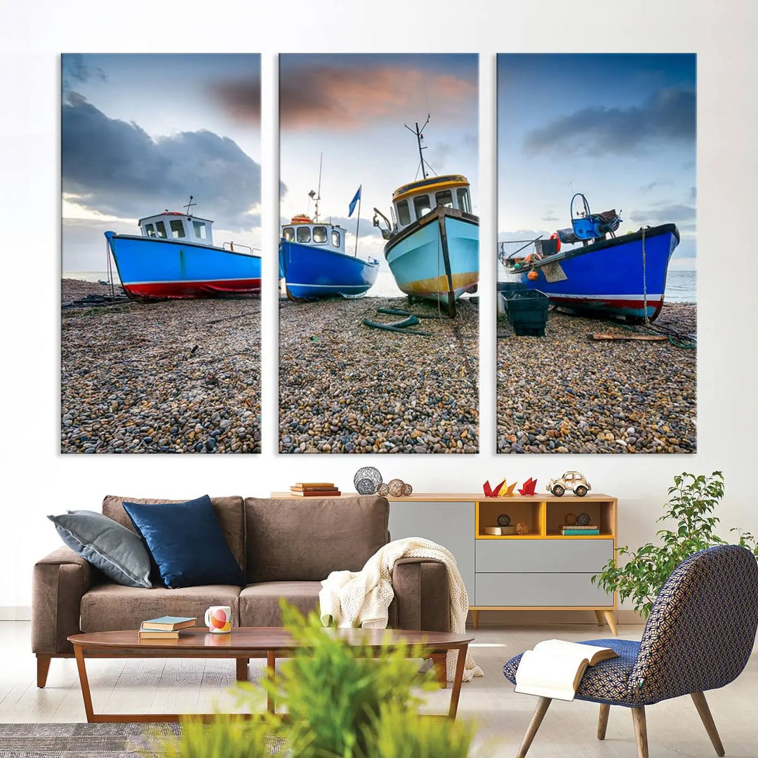 The "Big Boats On The Beach Wall Art Canvas Print" is a stunning piece featuring three museum-quality panels depicting fishing boats on a pebbled shore. Ready to hang and featuring UV-protective coating, it serves as an elegant addition to your home décor.