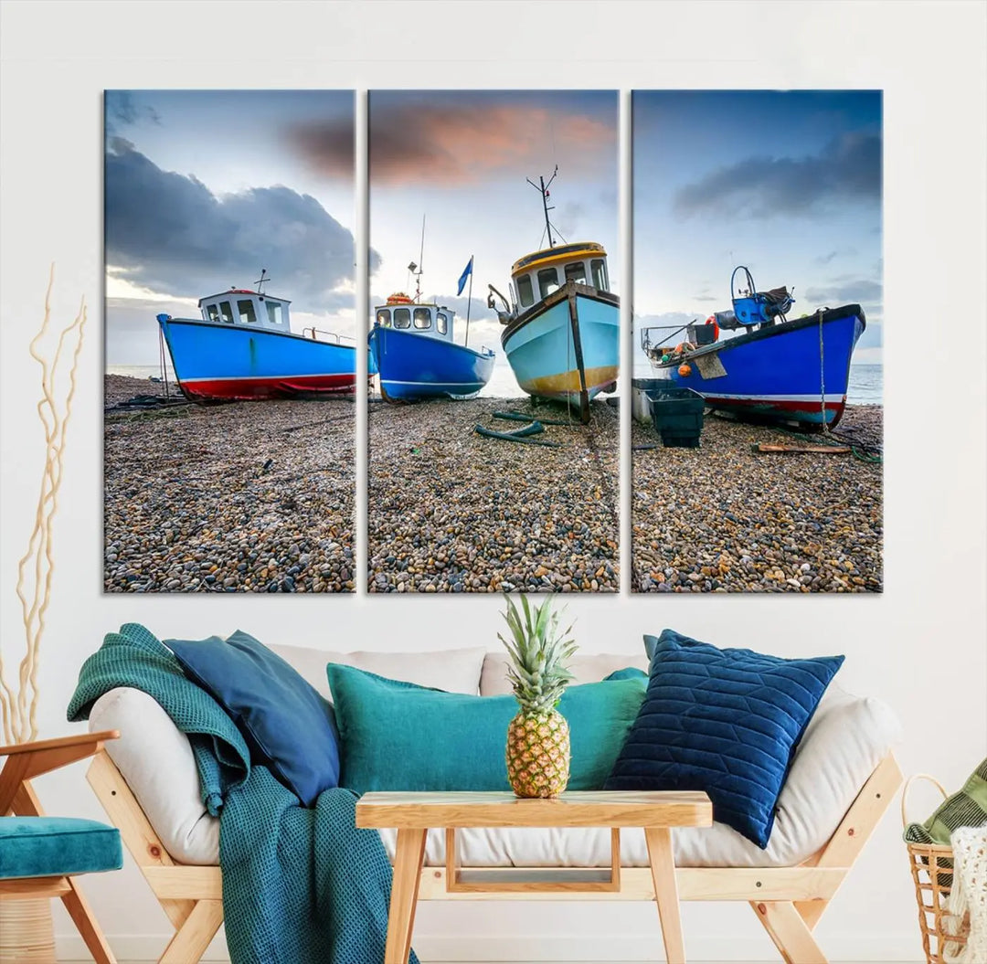 The "Big Boats On The Beach Wall Art Canvas Print" is a stunning piece featuring three museum-quality panels depicting fishing boats on a pebbled shore. Ready to hang and featuring UV-protective coating, it serves as an elegant addition to your home décor.