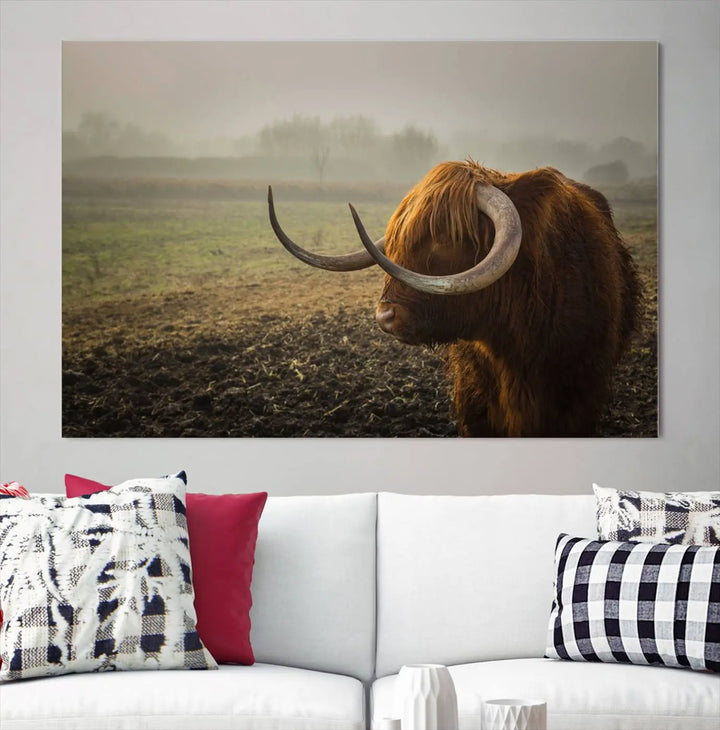 The "Big Cow Horn Wall Art Canvas Print" is a hand-assembled framed canvas depicting a Highland cow in a misty field. It is crafted with a UV-protective coating to ensure lasting vibrancy.