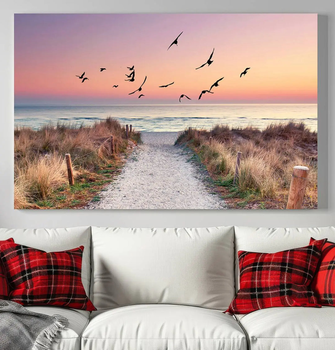 The "Birds on the Beach Sunset Wall Art Canvas Print" showcases a serene scene of seagulls soaring over a beach path at sunrise, beautifully capturing the endless sea and sky.