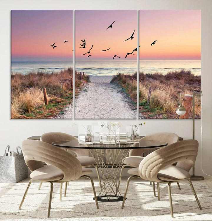 The "Birds on the Beach Sunset Wall Art Canvas Print" showcases a serene scene of seagulls soaring over a beach path at sunrise, beautifully capturing the endless sea and sky.