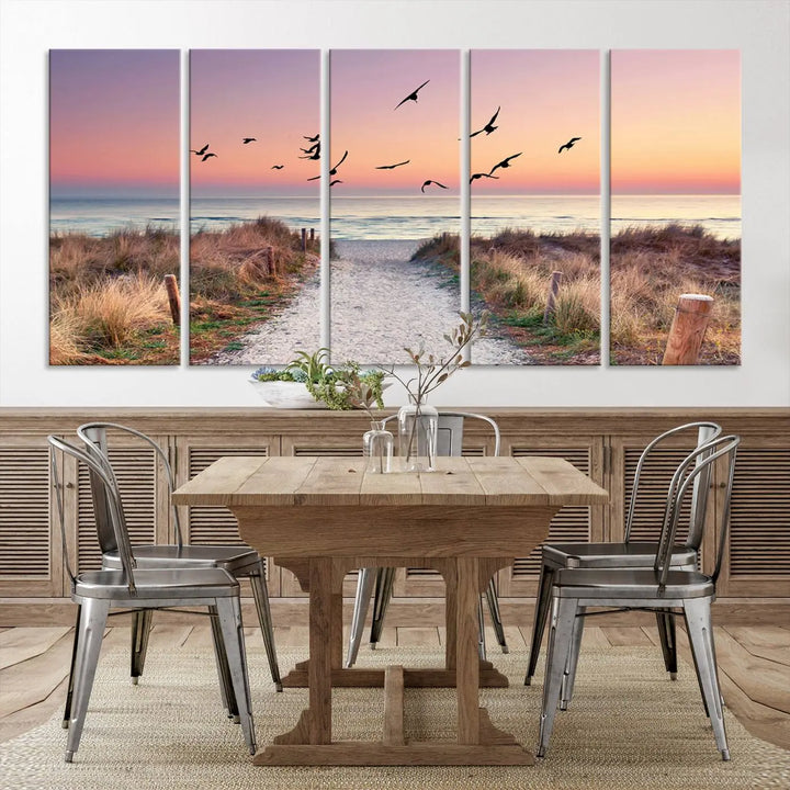 The "Birds on the Beach Sunset Wall Art Canvas Print" showcases a serene scene of seagulls soaring over a beach path at sunrise, beautifully capturing the endless sea and sky.