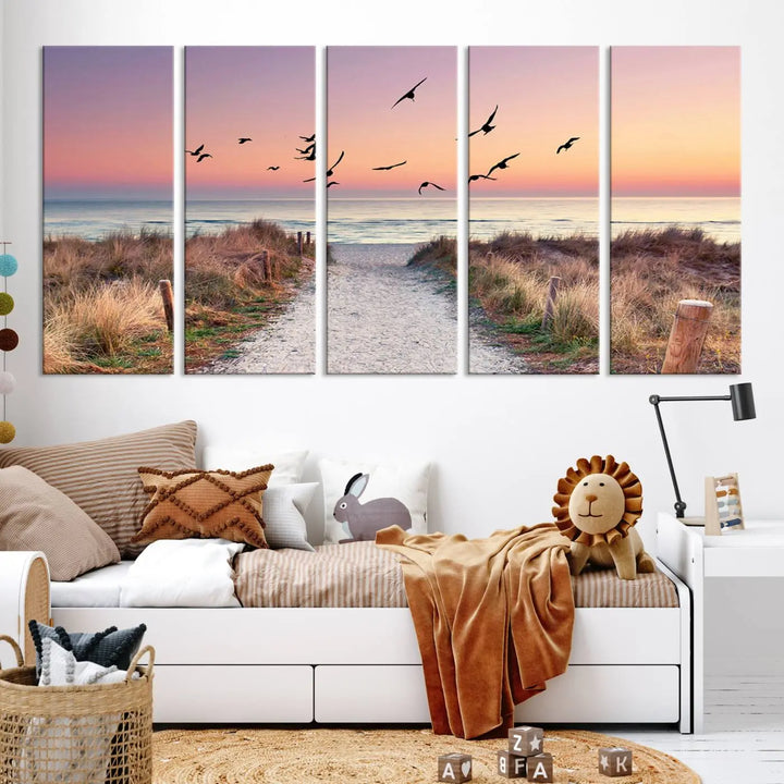 The "Birds on the Beach Sunset Wall Art Canvas Print" showcases a serene scene of seagulls soaring over a beach path at sunrise, beautifully capturing the endless sea and sky.