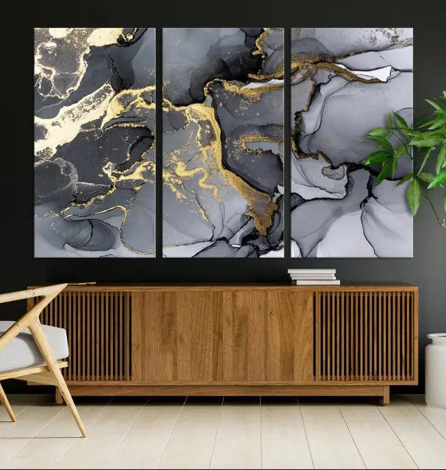 The Black Marble Fluid Effect Wall Art Abstract Canvas Wall Art Print features a triptych of black, gray, and gold abstract designs on museum-quality canvas. This elegant piece is ready to hang and includes a UV-protective coating to ensure its enduring allure.