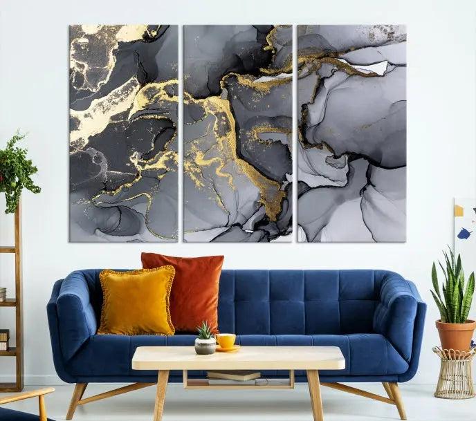 The Black Marble Fluid Effect Wall Art Abstract Canvas Wall Art Print features a triptych of black, gray, and gold abstract designs on museum-quality canvas. This elegant piece is ready to hang and includes a UV-protective coating to ensure its enduring allure.