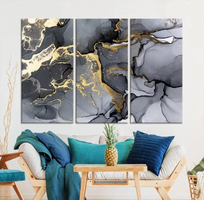 The Black Marble Fluid Effect Wall Art Abstract Canvas Wall Art Print features a triptych of black, gray, and gold abstract designs on museum-quality canvas. This elegant piece is ready to hang and includes a UV-protective coating to ensure its enduring allure.