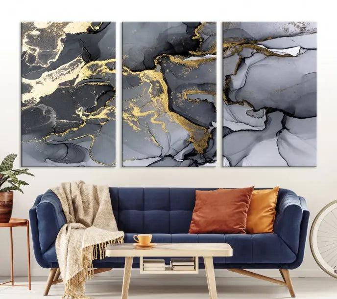 The Black Marble Fluid Effect Wall Art Abstract Canvas Wall Art Print features a triptych of black, gray, and gold abstract designs on museum-quality canvas. This elegant piece is ready to hang and includes a UV-protective coating to ensure its enduring allure.