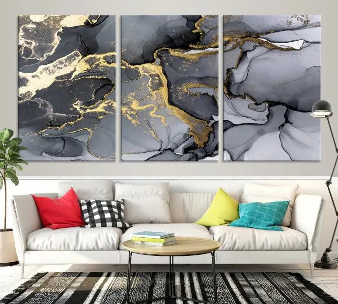 The Black Marble Fluid Effect Wall Art Abstract Canvas Wall Art Print features a triptych of black, gray, and gold abstract designs on museum-quality canvas. This elegant piece is ready to hang and includes a UV-protective coating to ensure its enduring allure.