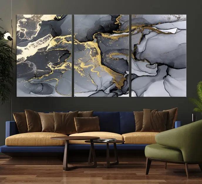 The Black Marble Fluid Effect Wall Art Abstract Canvas Wall Art Print features a triptych of black, gray, and gold abstract designs on museum-quality canvas. This elegant piece is ready to hang and includes a UV-protective coating to ensure its enduring allure.