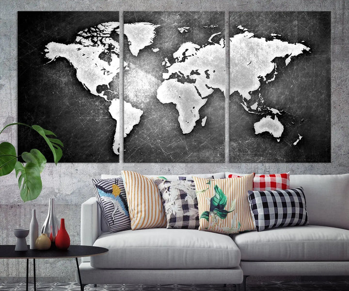 The Black Metallic Wall Art World Map Canvas Print, crafted on museum-quality canvas, adorns a textured wall. The gallery-wrapped artwork features a UV-protective coating that ensures the stunning colors will endure over time.