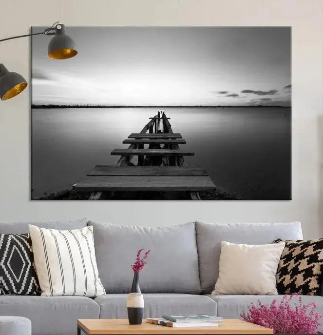 Titled "Black & White Old Wooden Pier Wall Art Canvas Print," this stunning monochrome triptych of a pier at sunset is printed on museum-grade canvases. It offers an effortlessly chic ambiance to your space with its ready-to-hang design.