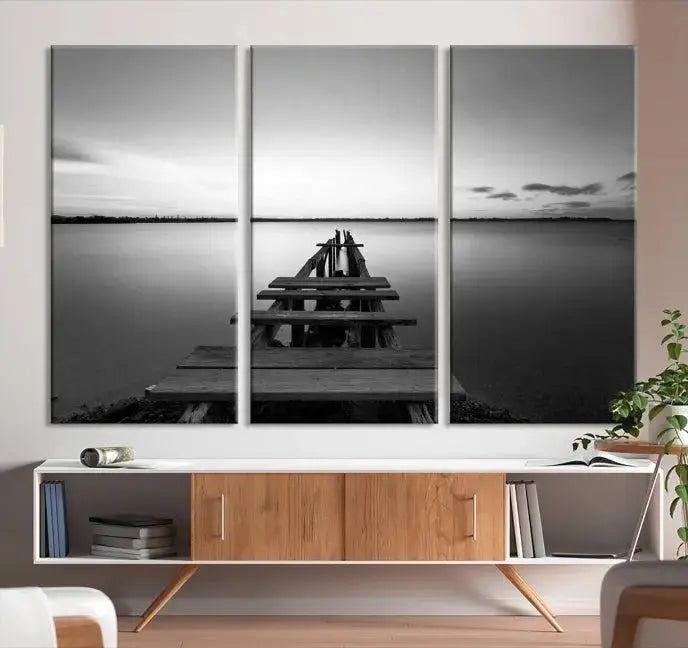 Titled "Black & White Old Wooden Pier Wall Art Canvas Print," this stunning monochrome triptych of a pier at sunset is printed on museum-grade canvases. It offers an effortlessly chic ambiance to your space with its ready-to-hang design.