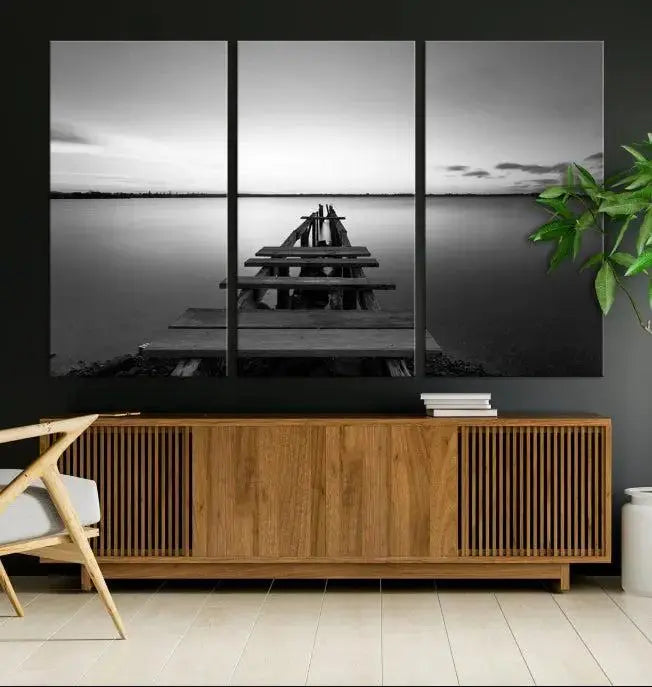 Titled "Black & White Old Wooden Pier Wall Art Canvas Print," this stunning monochrome triptych of a pier at sunset is printed on museum-grade canvases. It offers an effortlessly chic ambiance to your space with its ready-to-hang design.