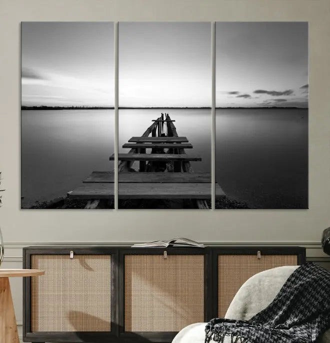 Titled "Black & White Old Wooden Pier Wall Art Canvas Print," this stunning monochrome triptych of a pier at sunset is printed on museum-grade canvases. It offers an effortlessly chic ambiance to your space with its ready-to-hang design.