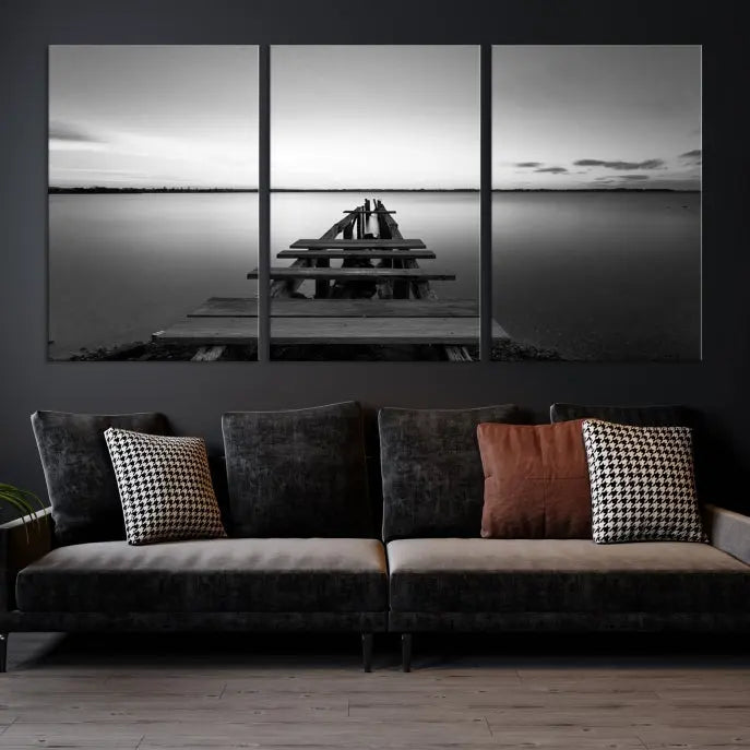 Titled "Black & White Old Wooden Pier Wall Art Canvas Print," this stunning monochrome triptych of a pier at sunset is printed on museum-grade canvases. It offers an effortlessly chic ambiance to your space with its ready-to-hang design.