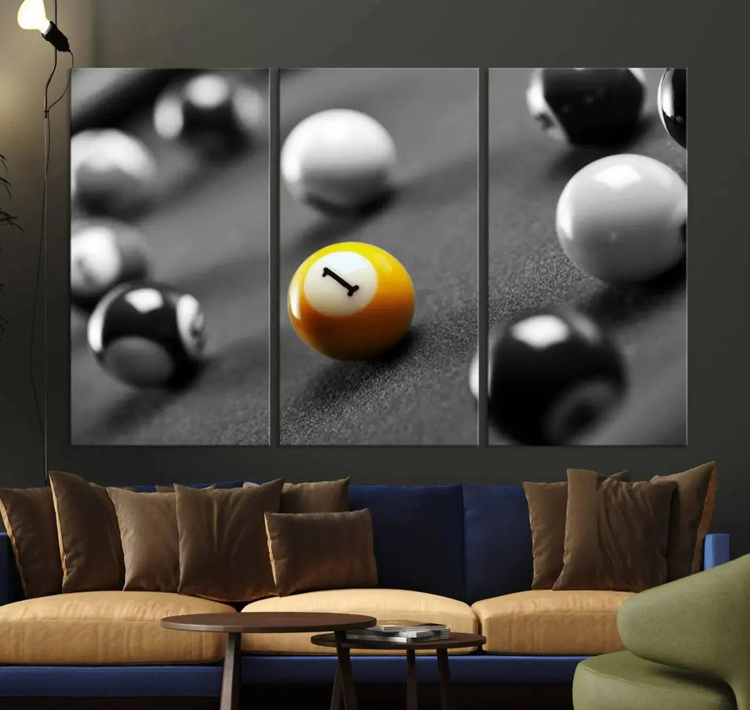 The modern living room features striking three-panel wall art titled "Black and White Concept Billiard Balls Canvas Print," showcasing a yellow number one ball on museum-quality canvas. This ready-to-hang piece is both stylish and convenient.