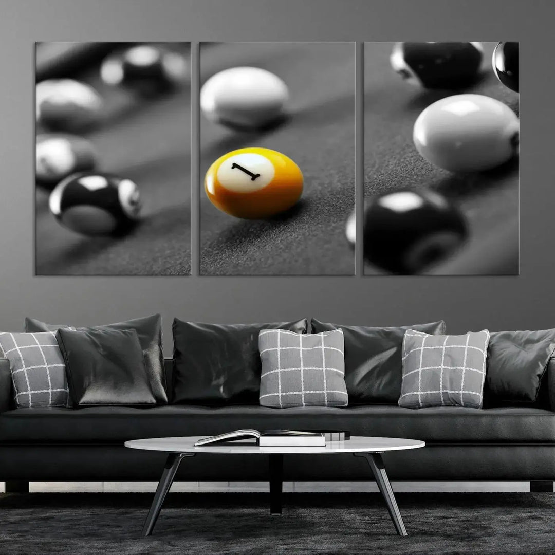 The modern living room features striking three-panel wall art titled "Black and White Concept Billiard Balls Canvas Print," showcasing a yellow number one ball on museum-quality canvas. This ready-to-hang piece is both stylish and convenient.