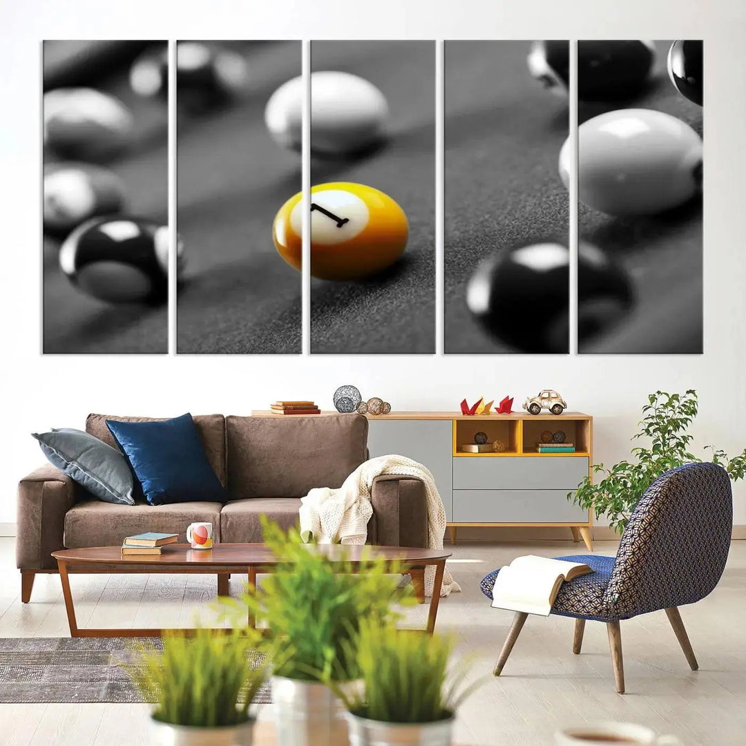 The modern living room features striking three-panel wall art titled "Black and White Concept Billiard Balls Canvas Print," showcasing a yellow number one ball on museum-quality canvas. This ready-to-hang piece is both stylish and convenient.