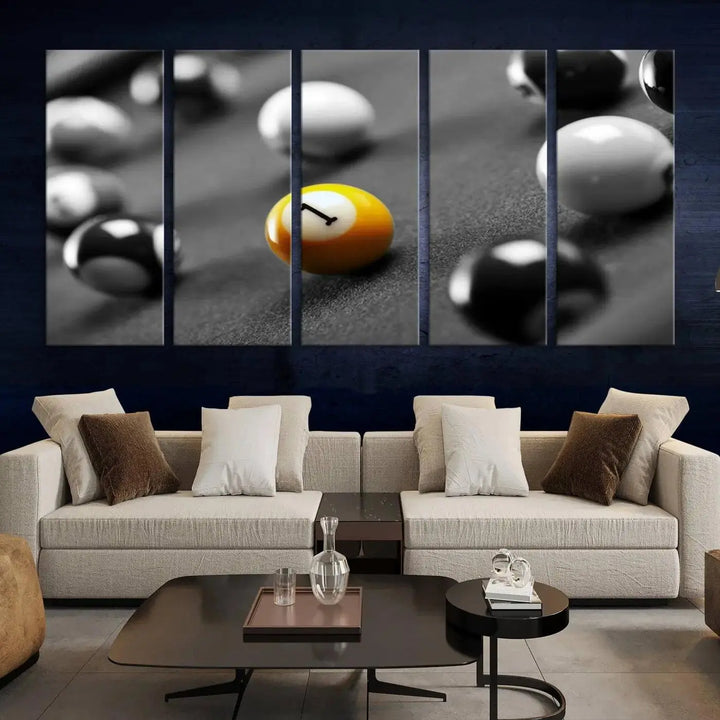 The modern living room features striking three-panel wall art titled "Black and White Concept Billiard Balls Canvas Print," showcasing a yellow number one ball on museum-quality canvas. This ready-to-hang piece is both stylish and convenient.