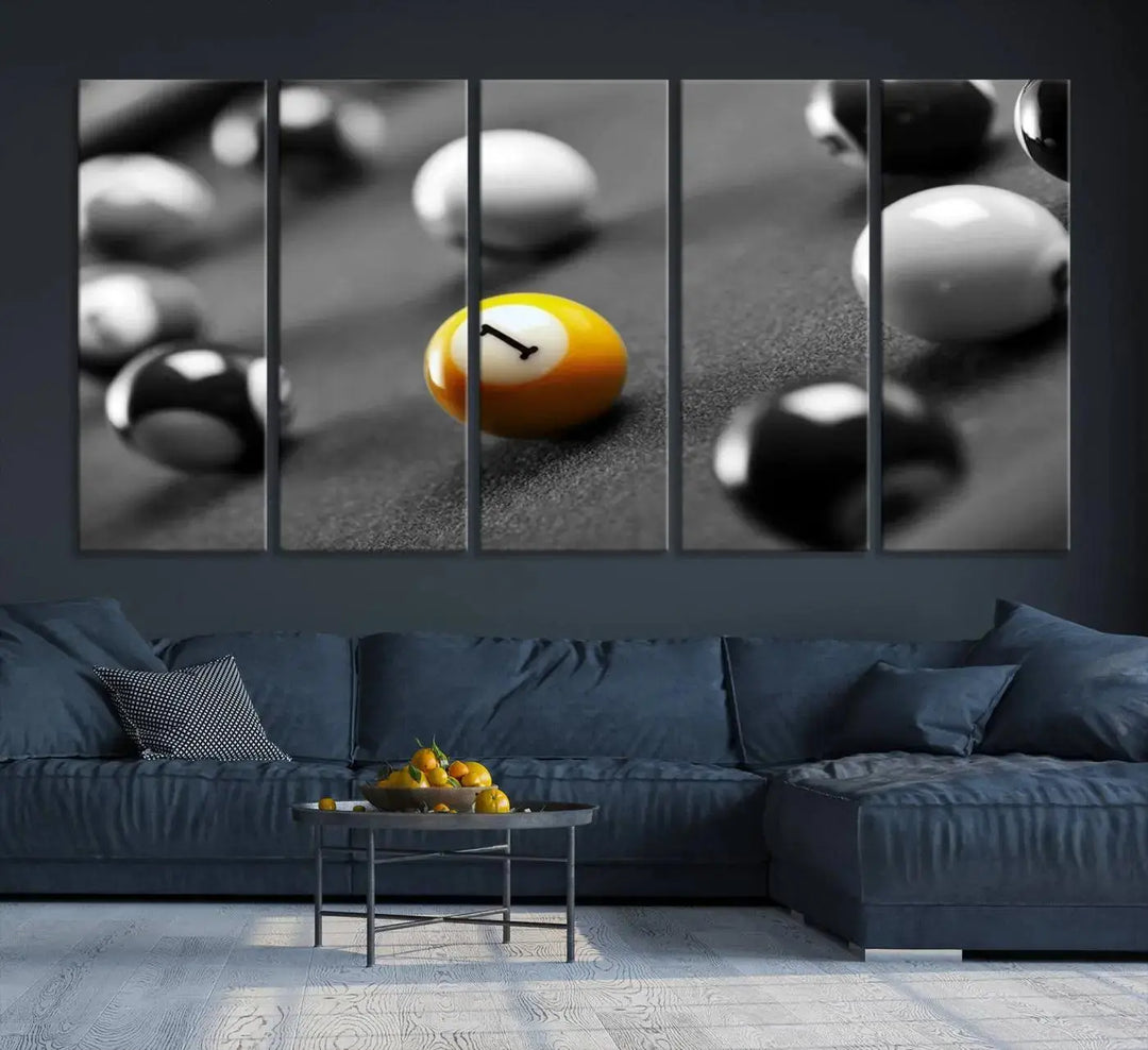 The modern living room features striking three-panel wall art titled "Black and White Concept Billiard Balls Canvas Print," showcasing a yellow number one ball on museum-quality canvas. This ready-to-hang piece is both stylish and convenient.