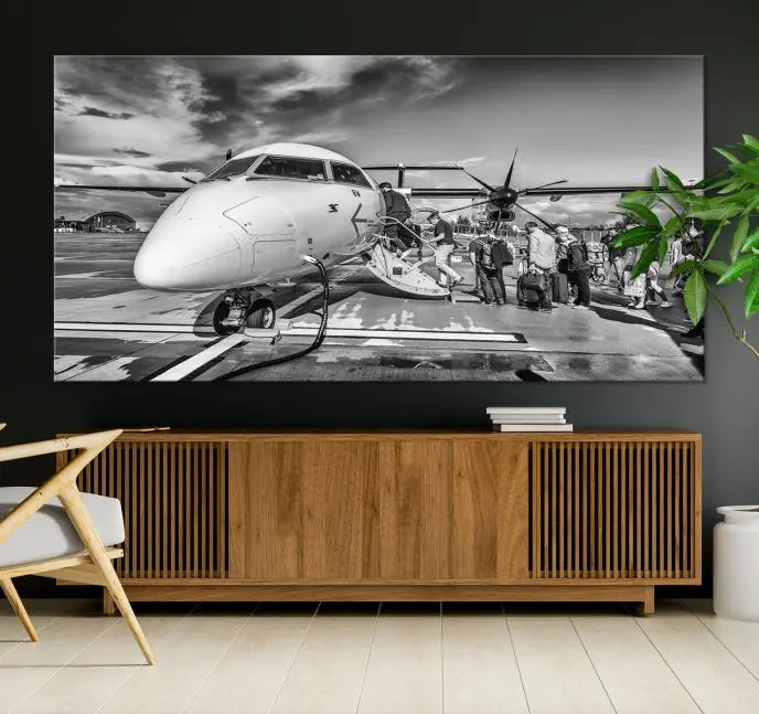 Introducing the Black and White Narrow Body Aircraft Wall Art Canvas Print: This striking three-panel canvas features a timeless black-and-white depiction of people boarding a propeller airplane. Printed on museum-quality canvas, each piece is UV-protected to maintain its vibrancy. These prints are ready to hang, making it easy to display them with ease.