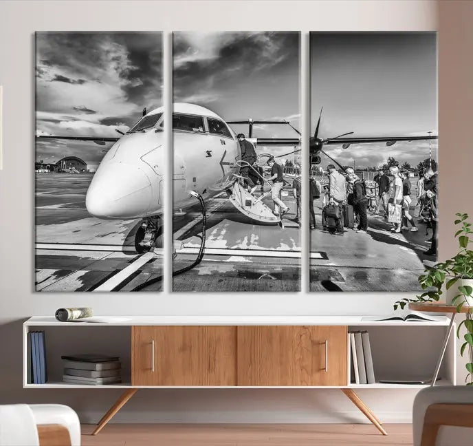 Introducing the Black and White Narrow Body Aircraft Wall Art Canvas Print: This striking three-panel canvas features a timeless black-and-white depiction of people boarding a propeller airplane. Printed on museum-quality canvas, each piece is UV-protected to maintain its vibrancy. These prints are ready to hang, making it easy to display them with ease.