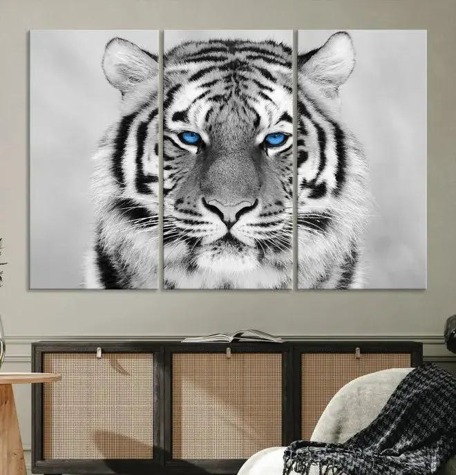 A piece from the Black and White Tiger Wall Art Animal Canvas Print collection, showcasing a white tiger with blue eyes on premium canvas, is displayed.